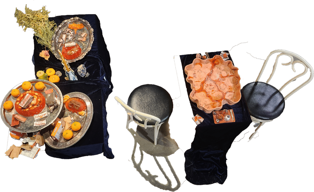 to the left, jello salad, suboxone wrappers, goldenrod and assorted orange foods arranged on a dark blue table cloth, referencing momento mori paintings. a table and chairs occupy the right picture plane, and an earthenware platter fills nearly the entire tabletop surface.